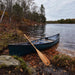 Bending Branches Beavertail Canoe Paddle leaning up against canoe by a lake